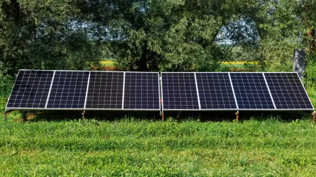 Güneş enerjisi santralinin kuşbakışı görünümü, gün ışığında parlayan paneller.